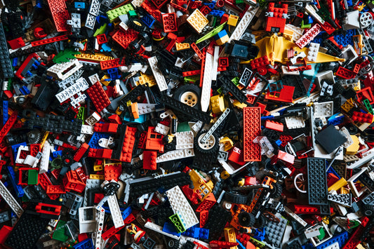 Eine bunte Sammlung von LEGO-Steinen in verschiedenen Farben und Formen, gestapelt und verstreut.