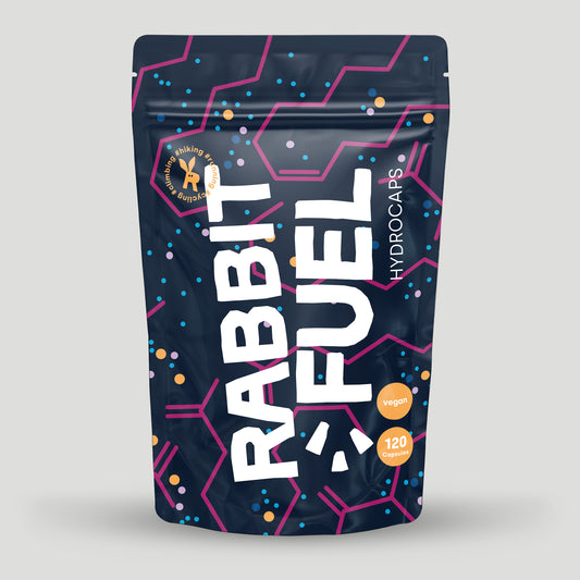 Verpackung von RabbitFuel Hydrocaps mit dunkelblauem Design, pinken und blauen grafischen Elementen sowie der Aufschrift vegan und 120 Capsules. Das Produkt ist für Outdoor-Aktivitäten wie Wandern oder Laufen gekennzeichnet.