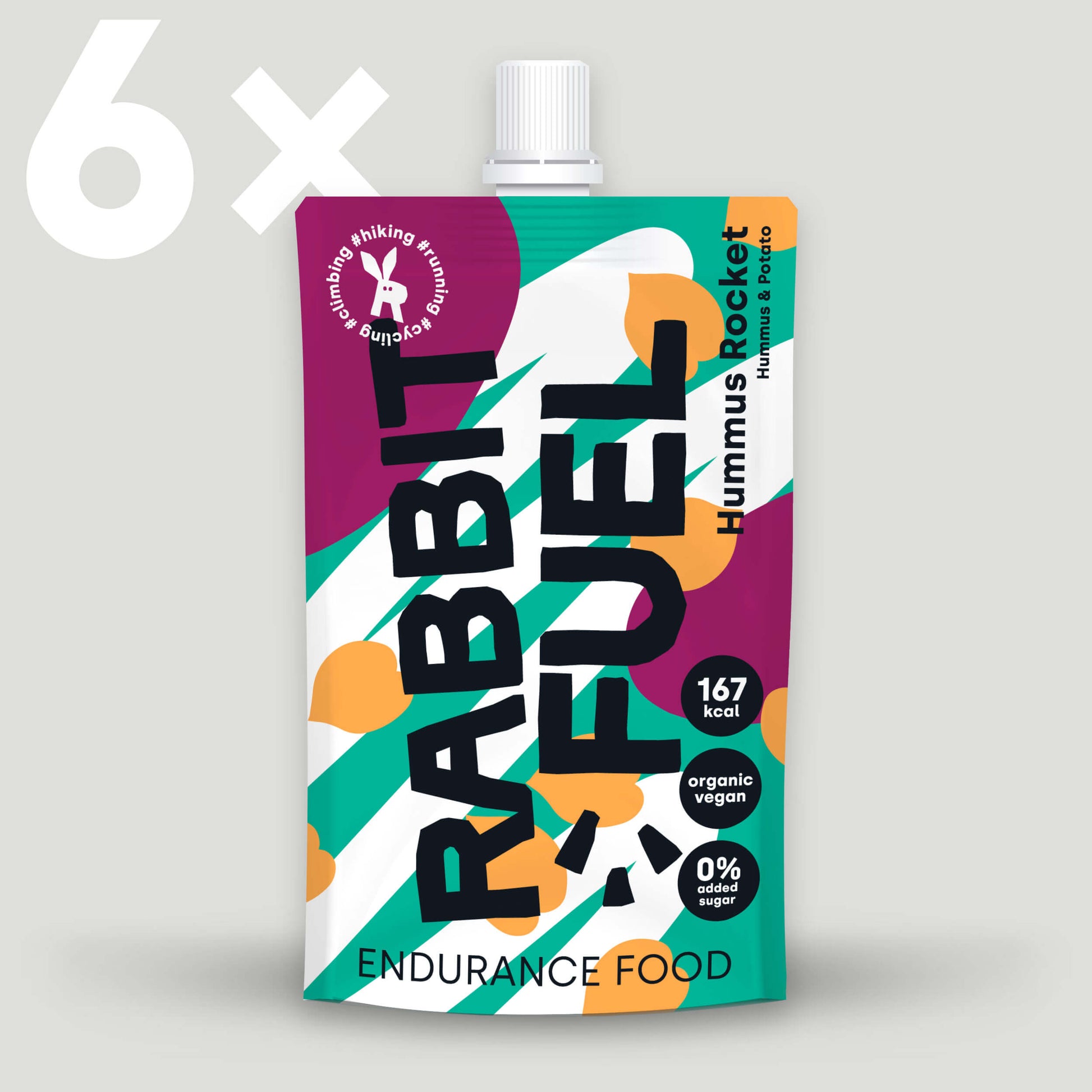 Produktabbildung einer Verpackung von ‚Rabbit Fuel Hummus Rocket‘ mit farbenfrohem Design in Lila, Grün und Orange. Die Verpackung zeigt die Aufschrift ‚Endurance Food‘ sowie Details wie 167 kcal, organic vegan und 0% added sugar. Oben links steht 6x, was auf eine Multipackung hinweist.